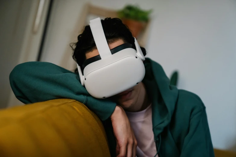 a man sitting on a couch wearing a virtual reality headset, by Carey Morris, trending on pexels, hyperrealism, vinny from vinesauce, facepalm, pictured from the shoulders up, video game item