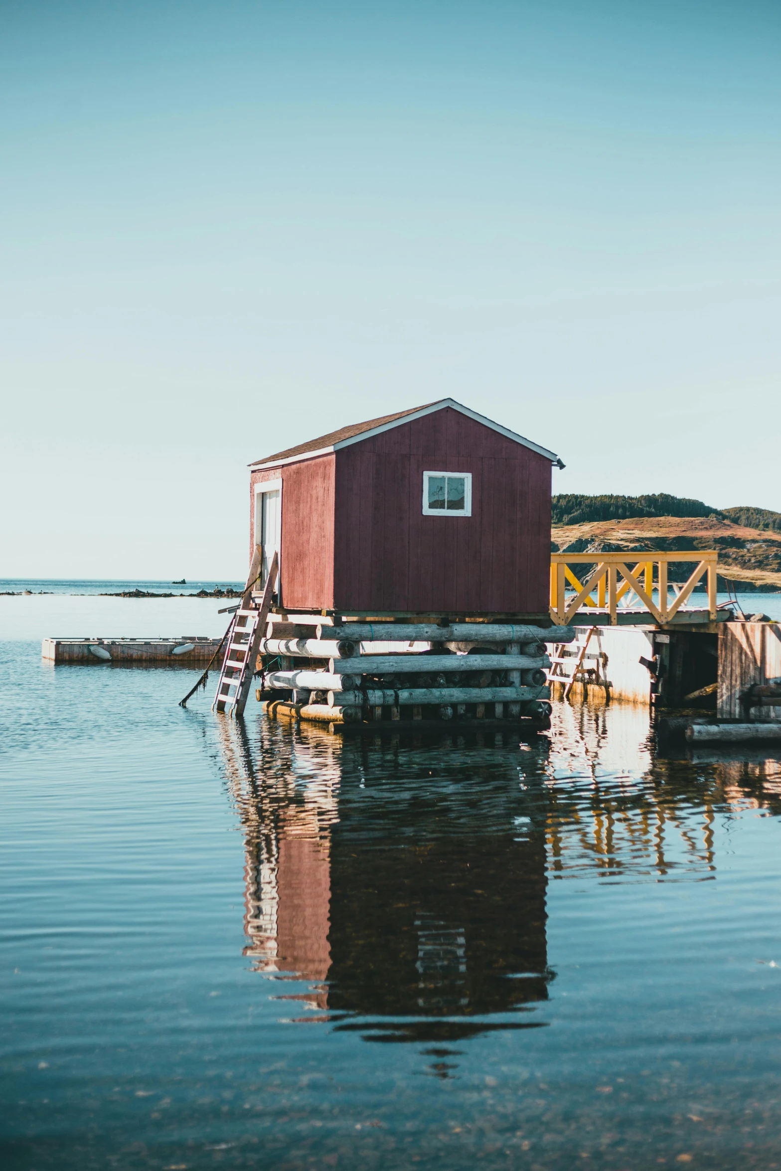 a red house sitting on top of a body of water, pexels contest winner, maritime, shed, in muted colors, sitting