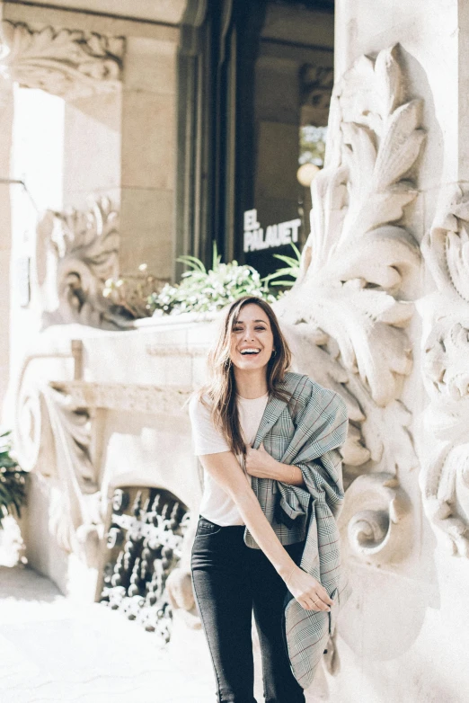 a woman posing for a picture in front of a building, sydney sweeney, shawl, smiling playfully, while marble