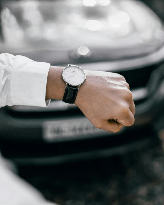 a close up of a person wearing a watch, inspired by Harry Haenigsen, pexels contest winner, full view of a car, white and silver, hindu, in gunmetal grey