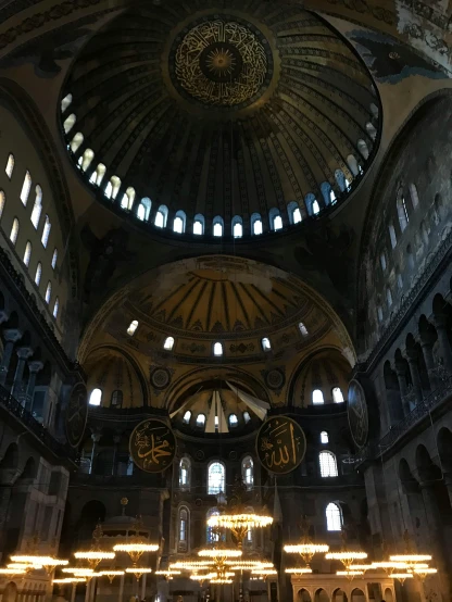 a group of people that are inside of a building, with great domes and arches, black, byzantine, with the sun shining on it