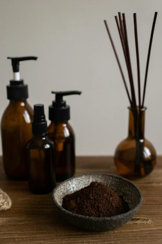 a brown bowl sitting on top of a wooden table, unsplash, bottles of spices, skincare, made of tar, promo image