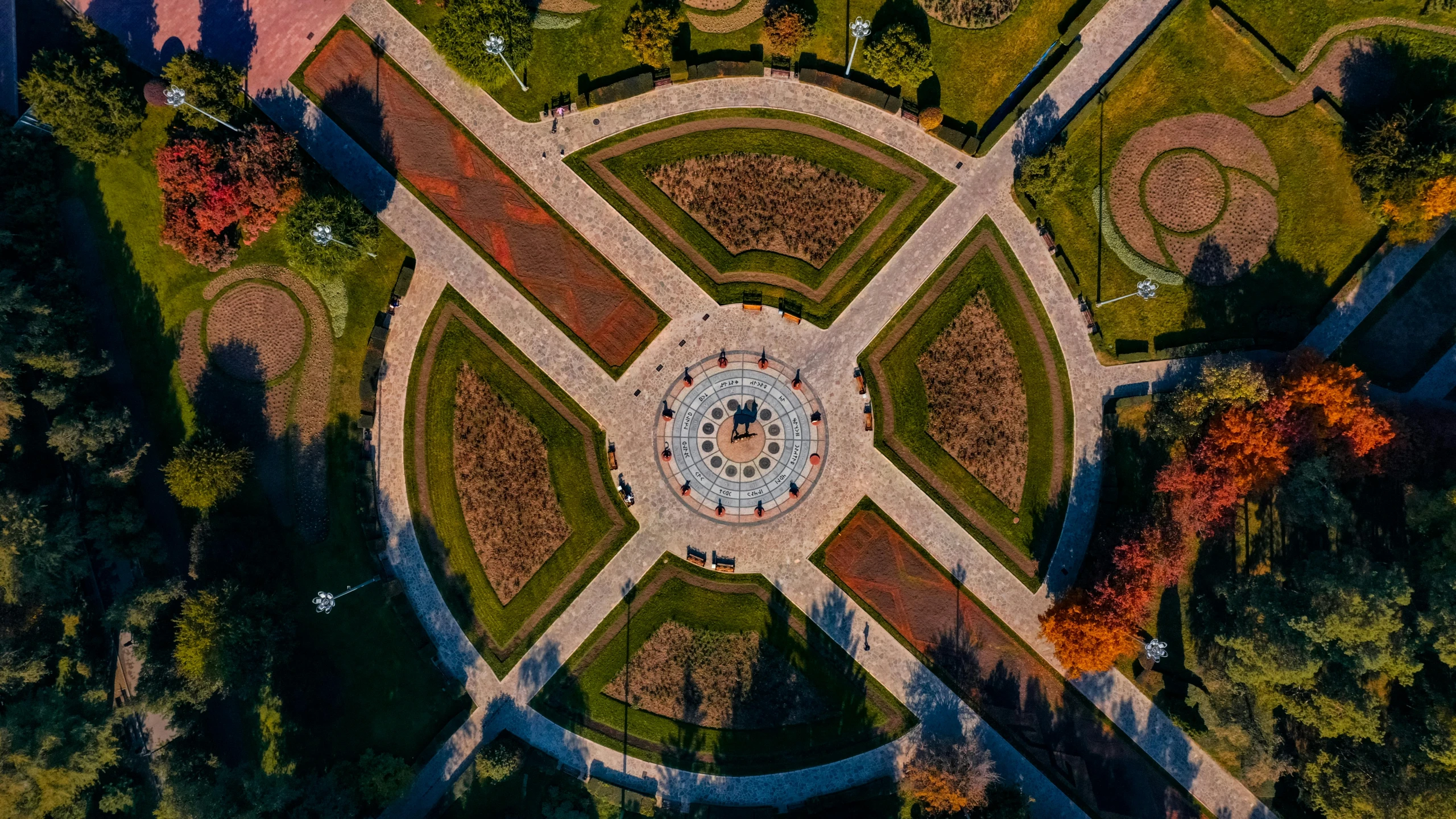 an aerial view of a circular park surrounded by trees, a mosaic, pexels contest winner, trip to legnica, thumbnail, sundial, brown