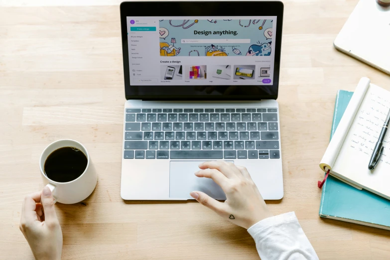 a laptop computer sitting on top of a wooden desk, by Julia Pishtar, trending on pexels, hand on table, featured on 9 9 designs, design your own avatar, 9 9 designs