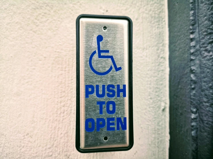 a close up of a sign on a wall, unsplash, wheelchair, opening door, square, pochi iida