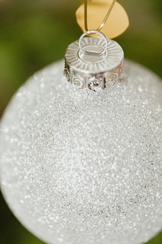 a white christmas ornament hanging from a tree, pointillism, close up of single sugar crystal, ashes crystal, detailed product image, detail shot