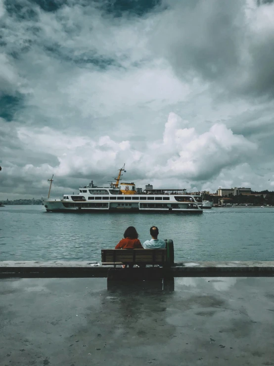 a couple of people that are sitting on a bench, a picture, by irakli nadar, pexels contest winner, hyperrealism, on ship, cloudy day, trending on vsco, harbour in background