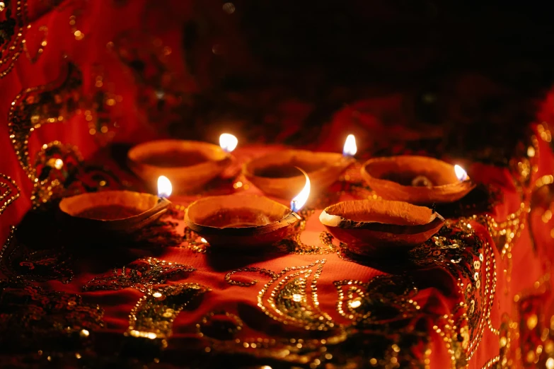 a group of candles sitting on top of a table, an album cover, pexels, hurufiyya, hindu ornaments, avatar image, small red lights, 2000s photo