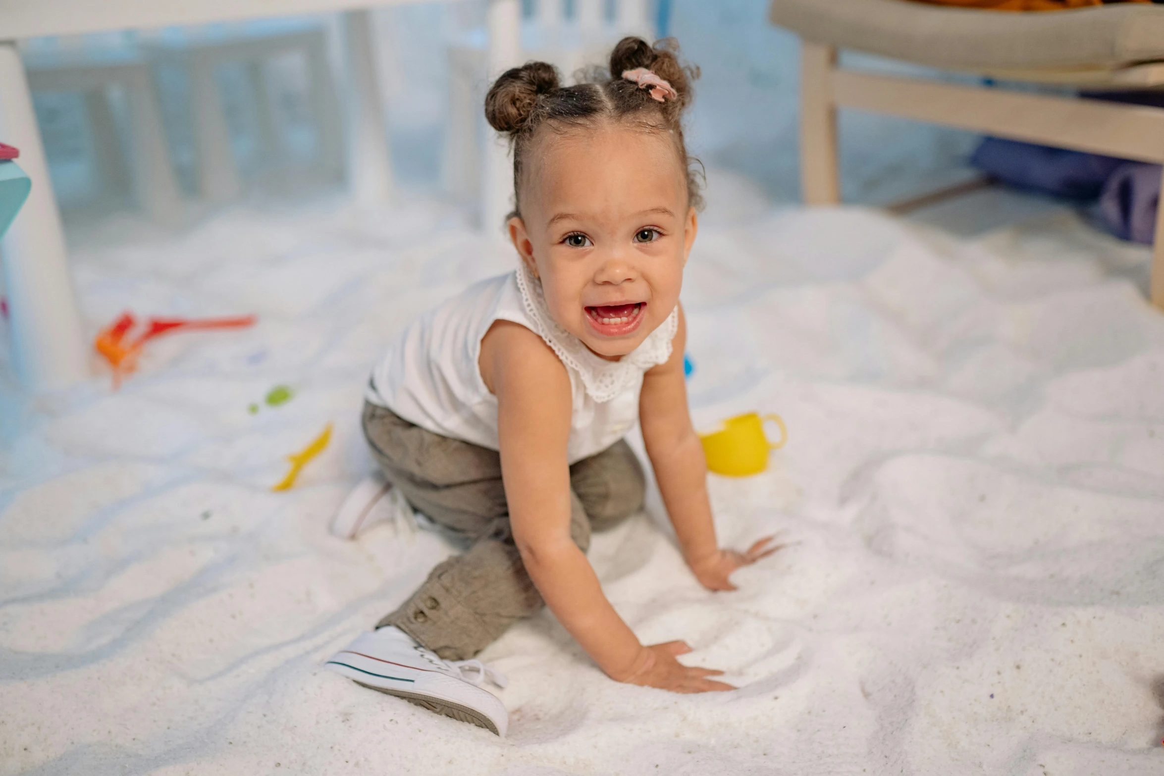 a little girl that is sitting in the sand, an album cover, inspired by Howardena Pindell, pexels contest winner, vanessa morgan, excited, softplay, white sand