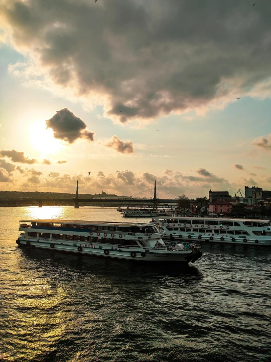 a couple of boats that are in the water, by Tom Wänerstrand, pexels contest winner, river gorgeous lighting, 🚿🗝📝, fallout style istanbul, sunset with cloudy skies