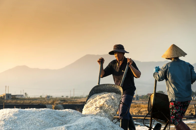 a couple of people standing on top of a pile of snow, villagers busy farming, covered in salt, top selection on unsplash, israel