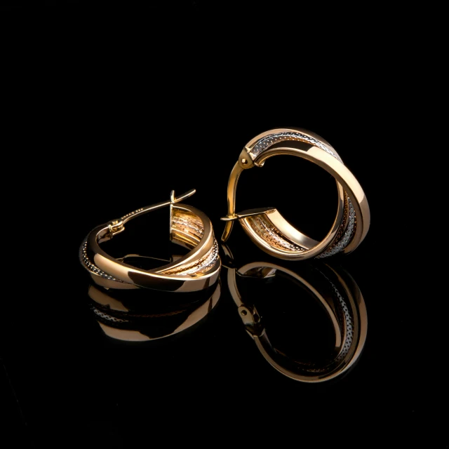 a pair of gold earrings on a black surface, by László Balogh, pixabay, shot on sony a 7, golden curve composition, thumbnail, high quality portrait