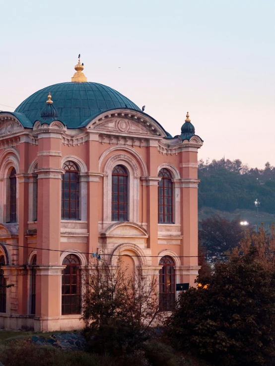 a large building sitting on top of a lush green hillside, an album cover, by Serhii Vasylkivsky, pexels contest winner, renaissance, mosque synagogue interior, pink golden hour, view from the street, profile image