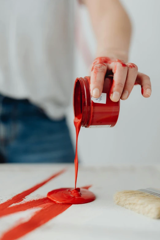 a person pouring red paint onto a table, perplexing, crafts, ready to eat, as well as scratches