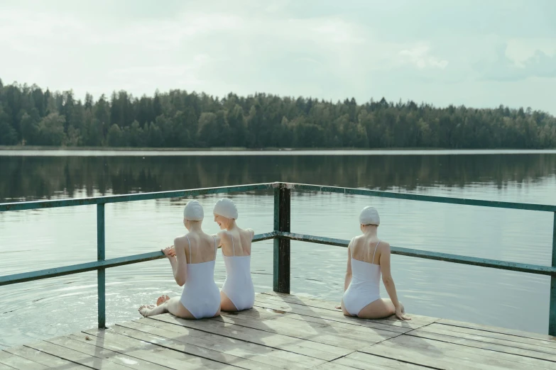 two women in white bathing suits sitting on a dock, inspired by Vanessa Beecroft, unsplash contest winner, purism, three women, finland, simin stalenhag, wearing a white bathing cap