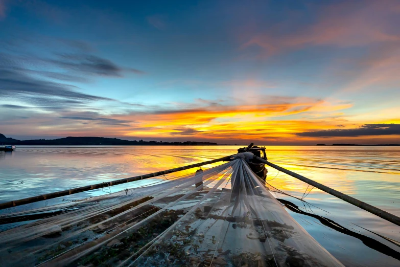 a boat sitting on top of a body of water, by Matthias Stom, unsplash contest winner, fish seafood markets, sunset panorama, crisp lines, indonesia national geographic