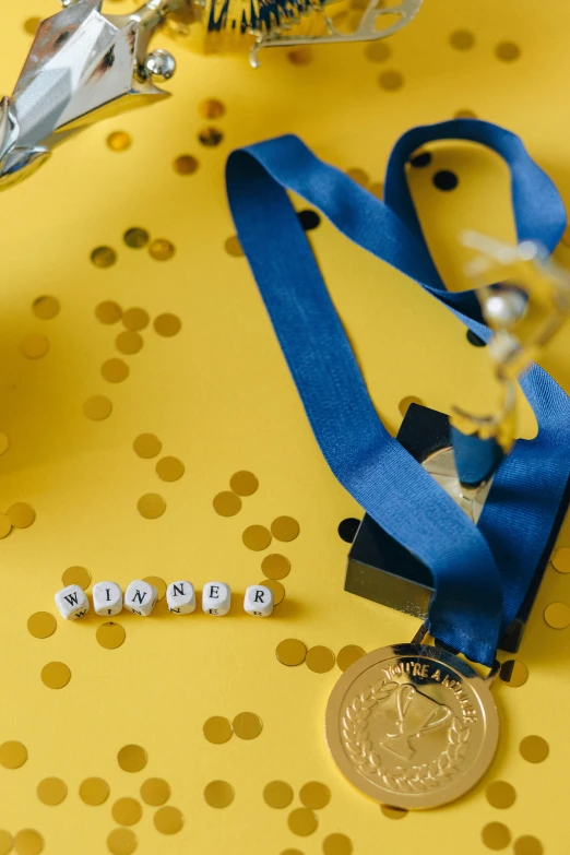 a pair of scissors sitting on top of a table, pexels contest winner, happening, wearing many medallions, yellow and blue ribbons, cubes on table, award wining photograph