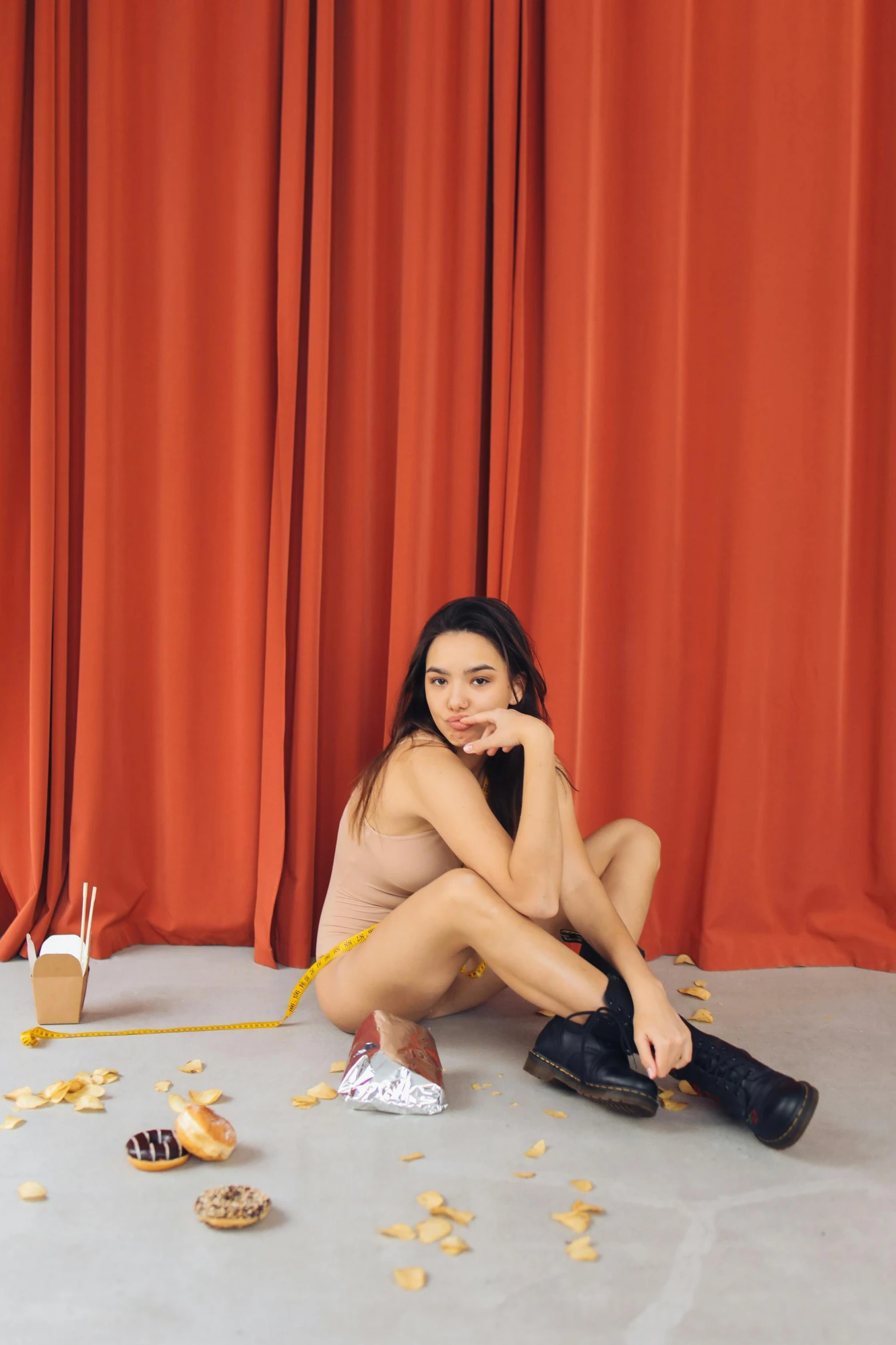 a naked woman sitting on the floor in front of a red curtain, inspired by Ren Hang, unsplash, with fries, dua lipa, steve zheng, showstudio