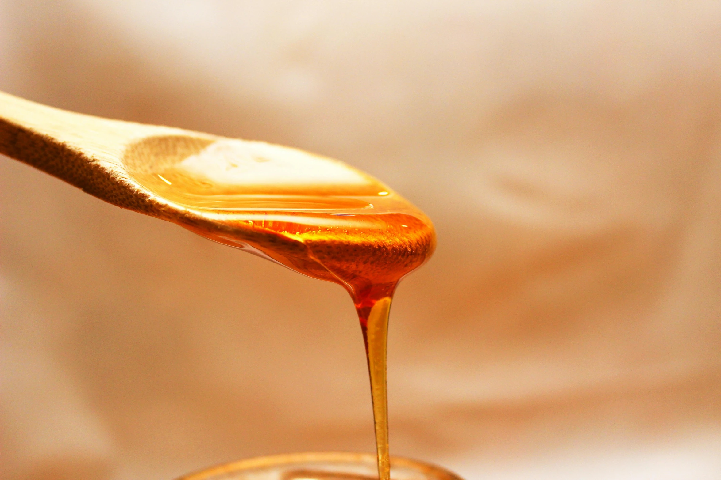 a spoon full of honey sitting on top of a jar, trending on pexels, light tan, draped in shiny oil, multi-part, tan