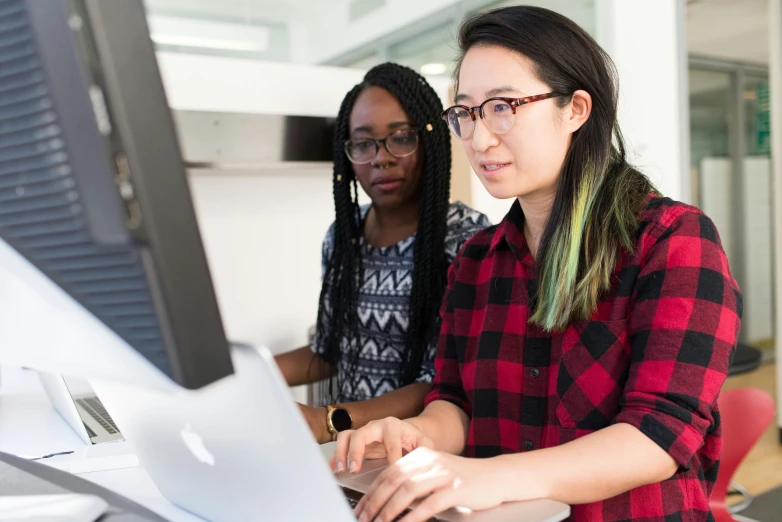 a couple of women sitting in front of a computer, computer graphics, trending on unsplash, mit technology review, programmer, louise zhang, 9 9 designs