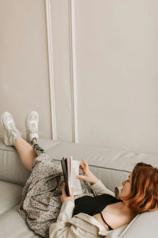 a woman laying on a couch reading a book, trending on pexels, happening, prosthetic leg, portrait full body, gen z, 1 2 9 7