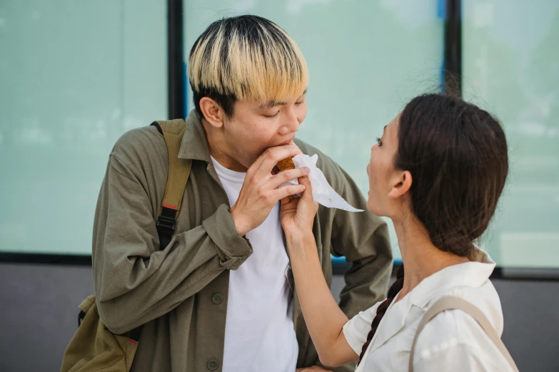 a man standing next to a woman eating a donut, pexels contest winner, asian face, eating a mushroom, on a hot australian day, gum tissue