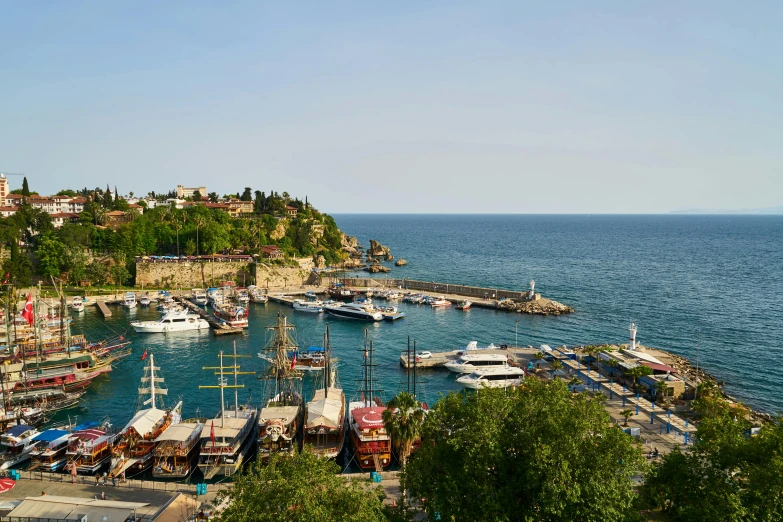 a harbor filled with lots of boats under a blue sky, pexels, hurufiyya, bulgari, located in hajibektash complex, cliffside, conde nast traveler photo