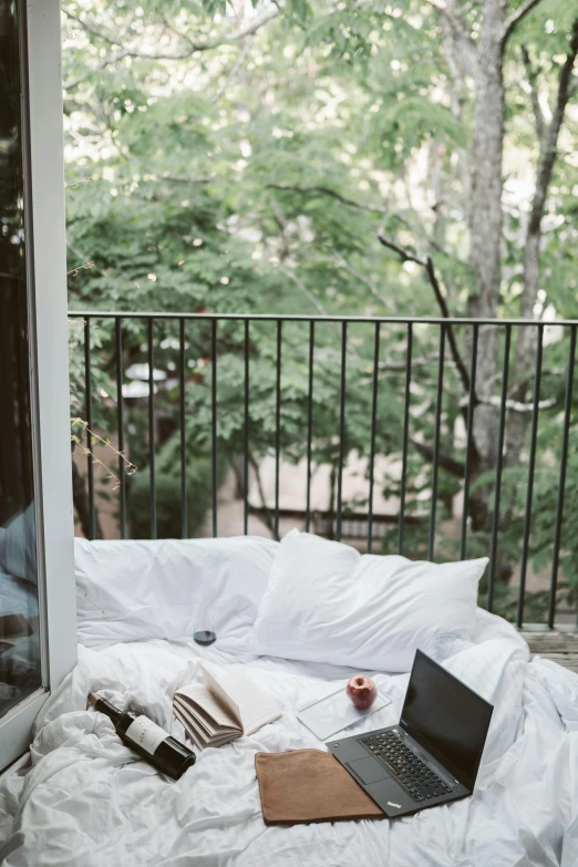 a laptop computer sitting on top of a bed, inspired by Elsa Bleda, unsplash contest winner, eating outside, balcony door, sitting in a tree, white