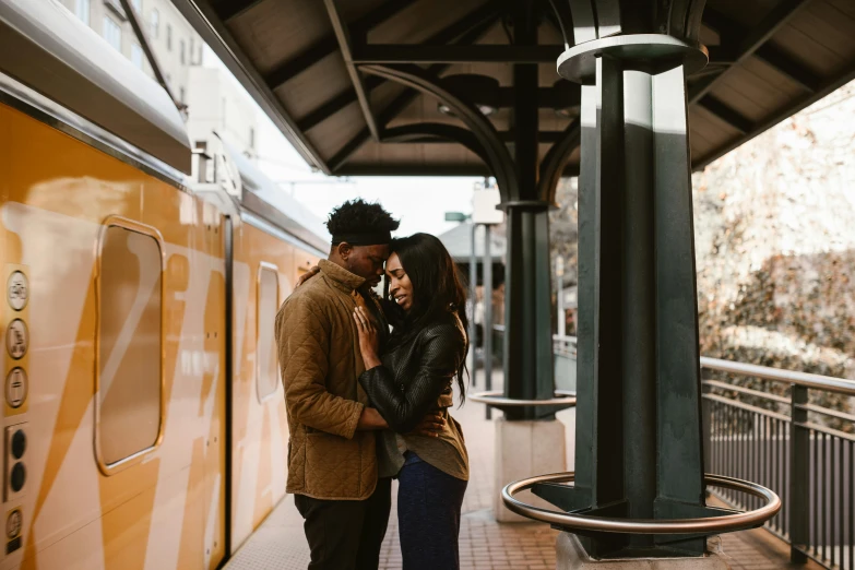 a man and woman standing in front of a train, trending on unsplash, beautiful city black woman only, hugging each other, jordan matter photography, thumbnail