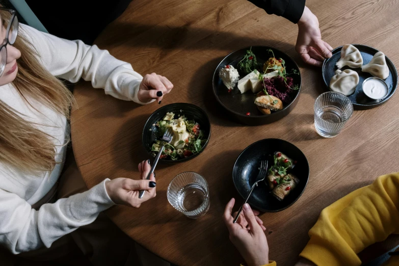 a group of people sitting at a table with plates of food, pexels contest winner, purism, subsurface scandering, four hands, thumbnail, winter