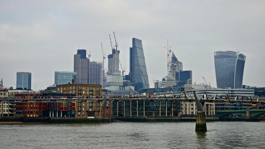 a large body of water with a bunch of buildings in the background, inspired by Thomas Struth, pexels contest winner, thames river, construction, three towers, grey
