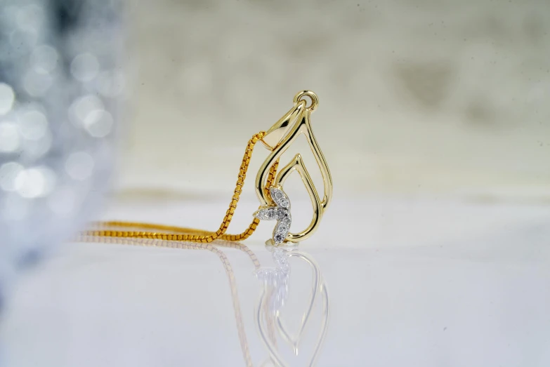 a close up of a necklace on a table, a macro photograph, by Julian Allen, trending on pexels, arabesque, golden curve composition, miniature product photo, ornate with white diamonds, gold light