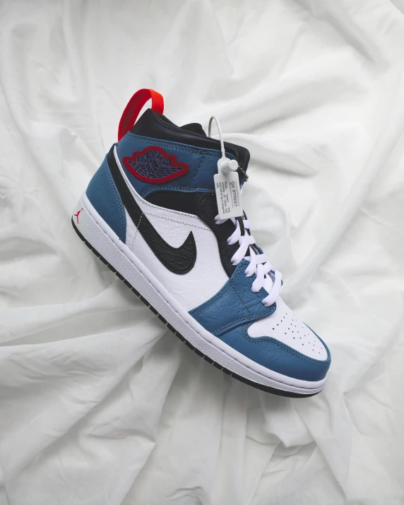 a pair of sneakers sitting on top of a bed, air jordan 1 high, ((blue)), dark blue and red, profile pic