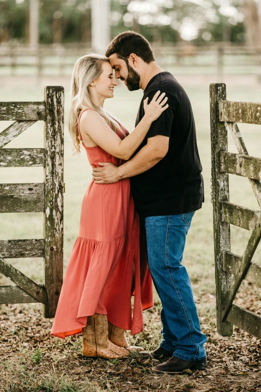 a couple standing next to each other in front of a fence, profile image