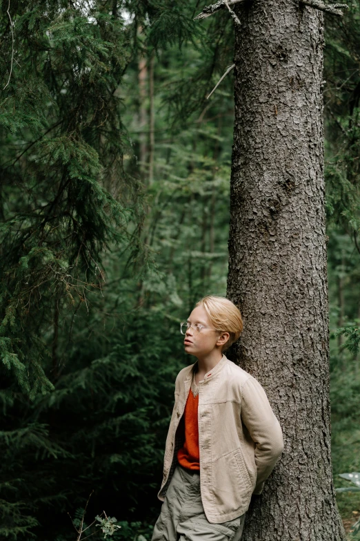 a man standing next to a tree in a forest, by Jaakko Mattila, unsplash, portrait tilda swinton, woman, ((forest)), ignant