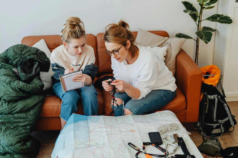 a couple of women sitting on top of a couch, a cross stitch, pexels contest winner, map cartography, first aid kit, college students, profile image