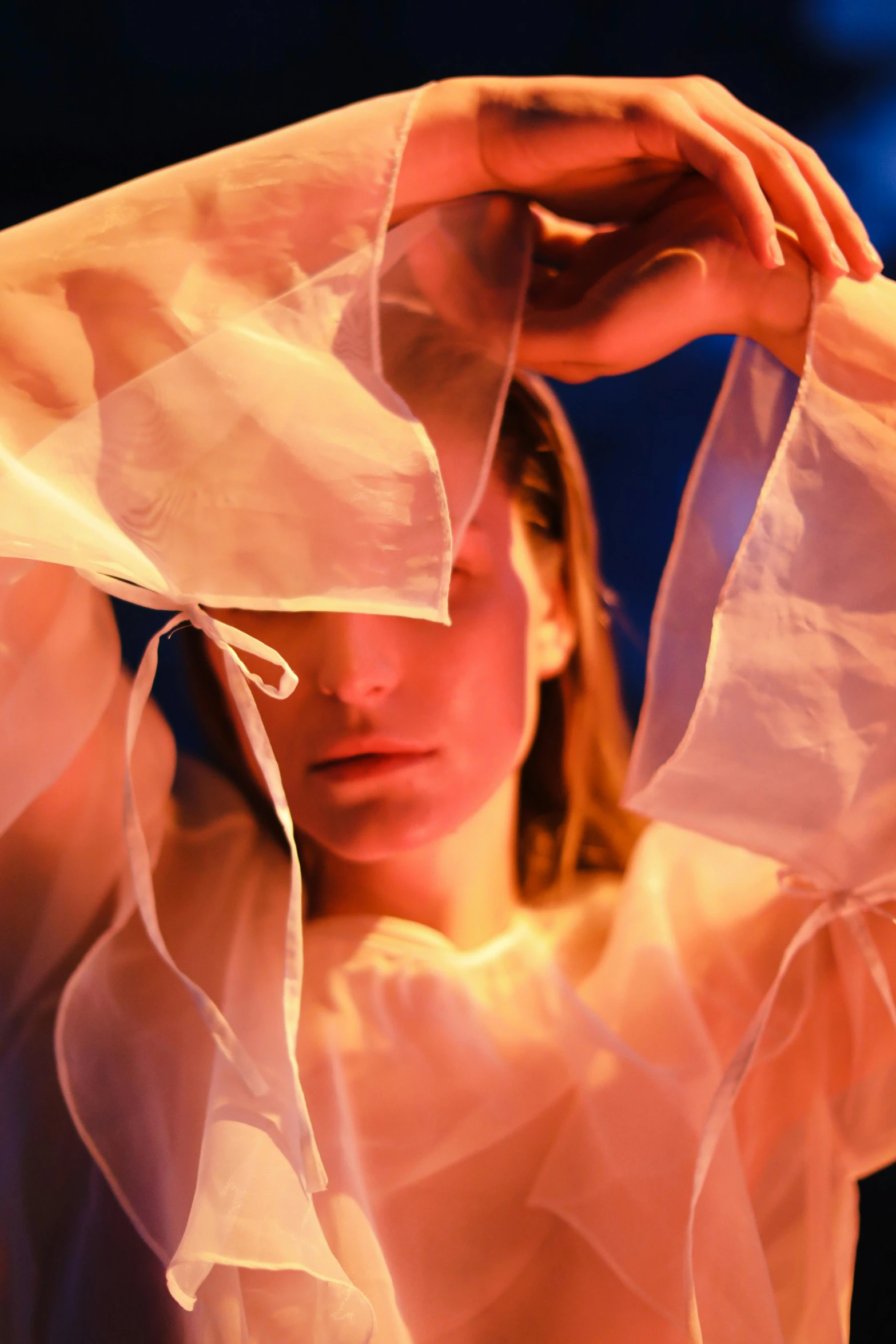 a woman with a veil over her head, an album cover, inspired by Anna Füssli, unsplash, conceptual art, soft translucent fabric folds, flowing neon-colored silk, covered in bandages, warm light