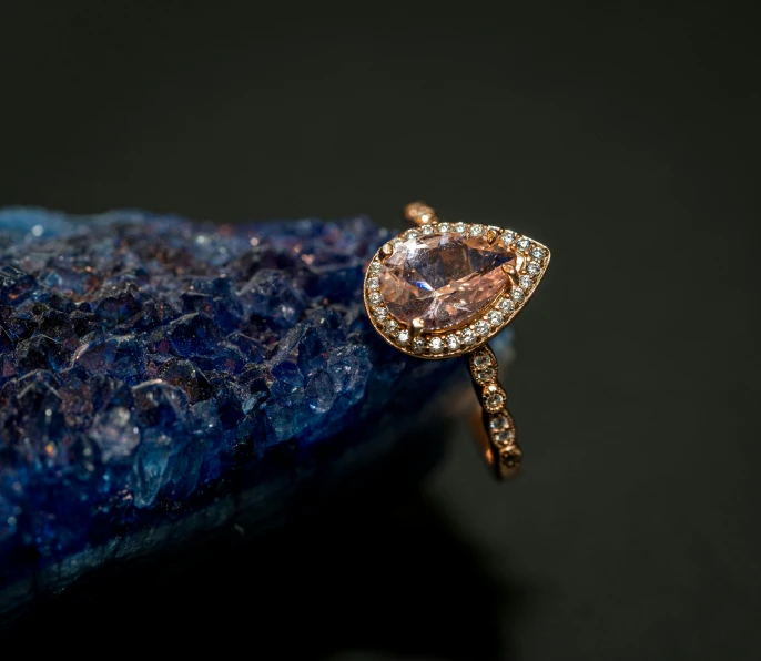 a close up of a ring on a rock, peach embellishment, jewelry lighting, thumbnail, tear drop