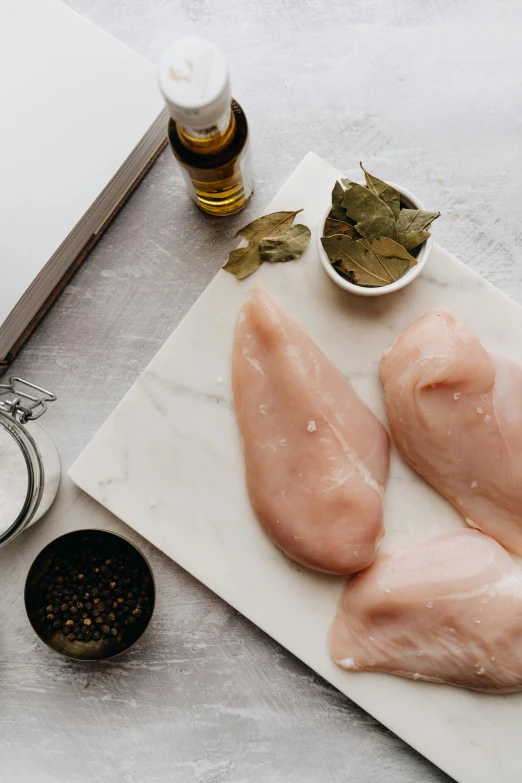 two pieces of chicken sitting on top of a cutting board, a picture, trending on pexels, renaissance, smooth marble surfaces, 6 pack, herbs, sc-fi