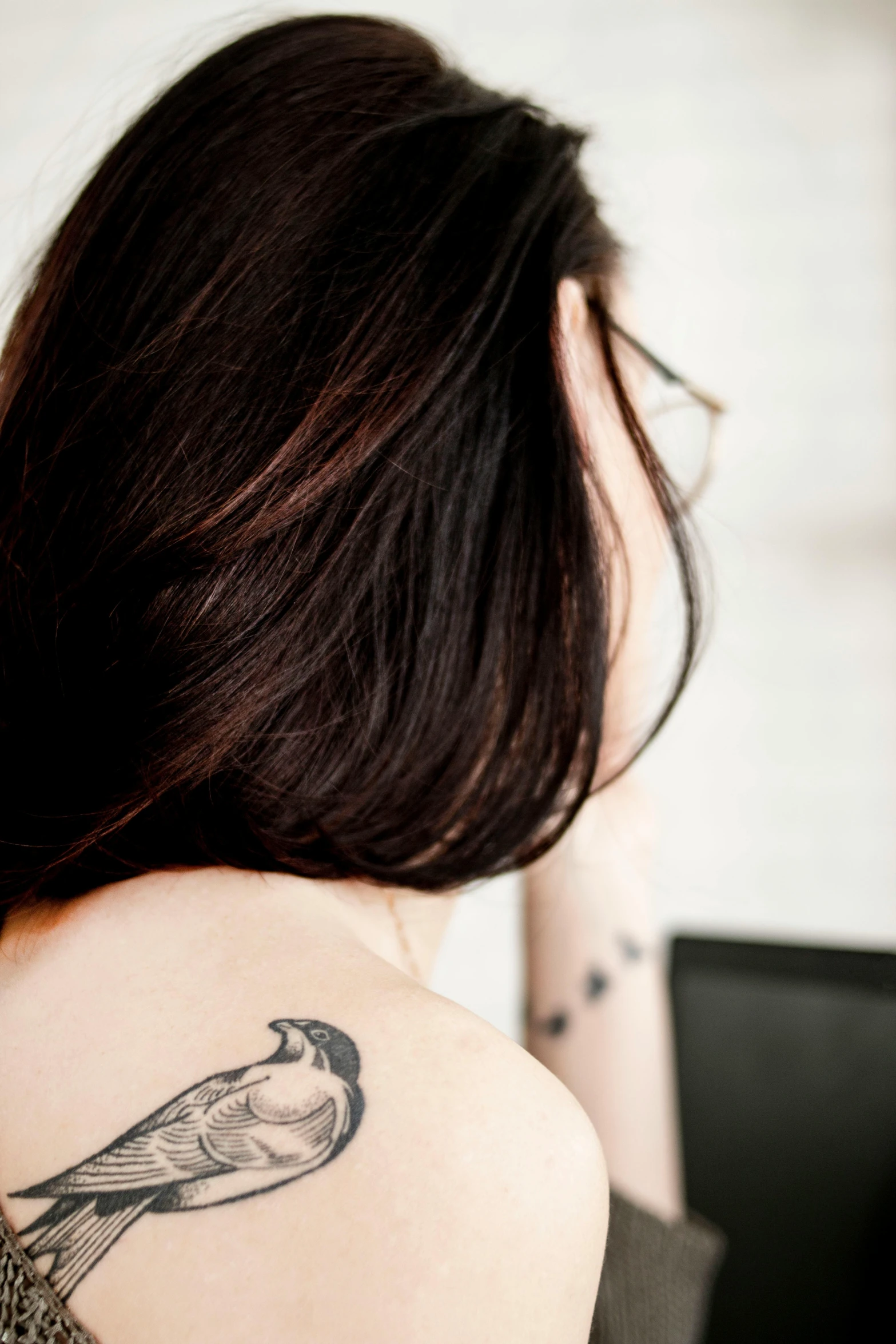 a woman with a bird tattoo on her back, a tattoo, trending on pexels, the woman has long dark hair, profile image, slightly pixelated, stoya