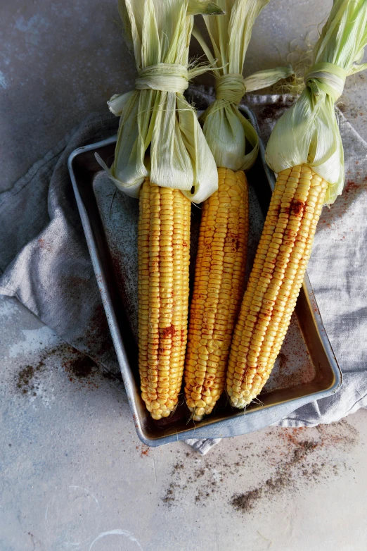 a tray filled with corn sitting on top of a table, charred, large tall, 1 6 x 1 6, a pair of ribbed