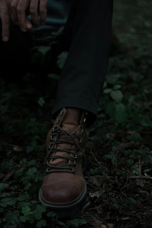 a man sitting on the ground next to a fire hydrant, an album cover, by Elsa Bleda, trending on pexels, wears brown boots, evening!! in the forest, chocolate. rugged, medium close-up shot