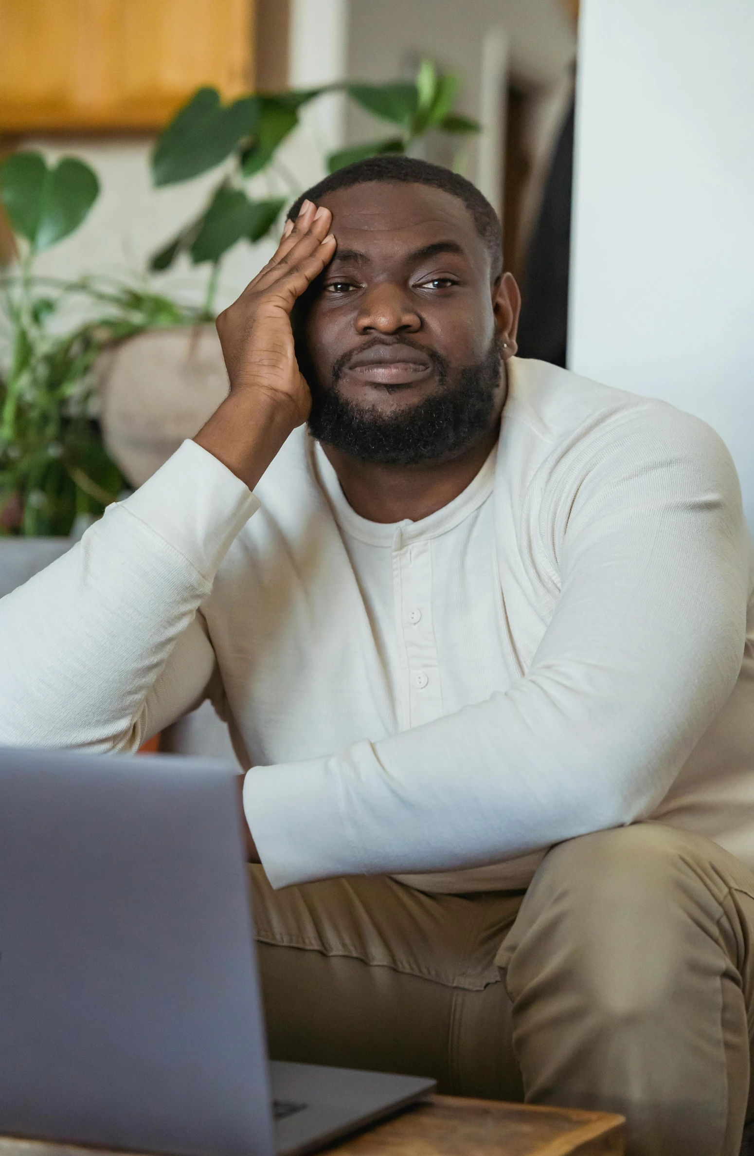 a man sitting on a couch in front of a laptop, disappointed, african canadian, promo image, taken in 2 0 2 0