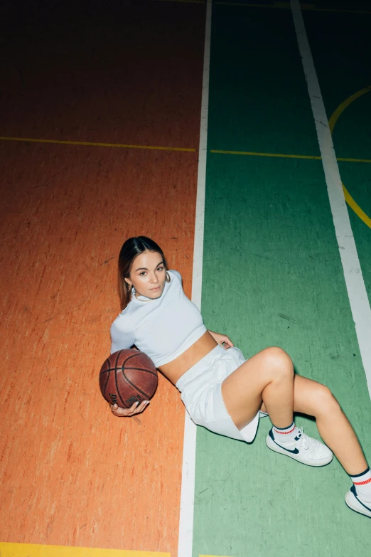 a woman laying on a basketball court holding a basketball, inspired by Ion Andreescu, trending on dribble, sasha grey, sports illustrated, kiko mizuhara, high school