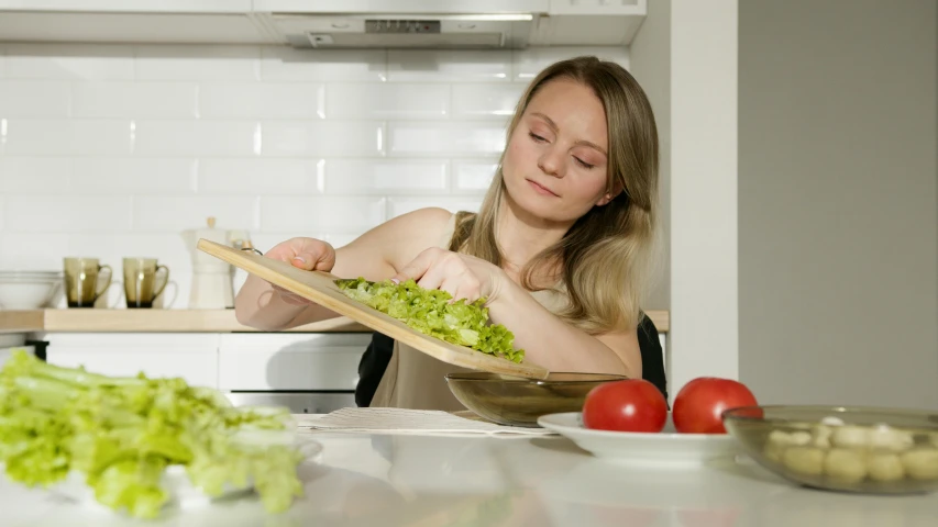 a woman is preparing a salad in the kitchen, pexels contest winner, aurora aksnes, fan favorite, still frame, low quality photo