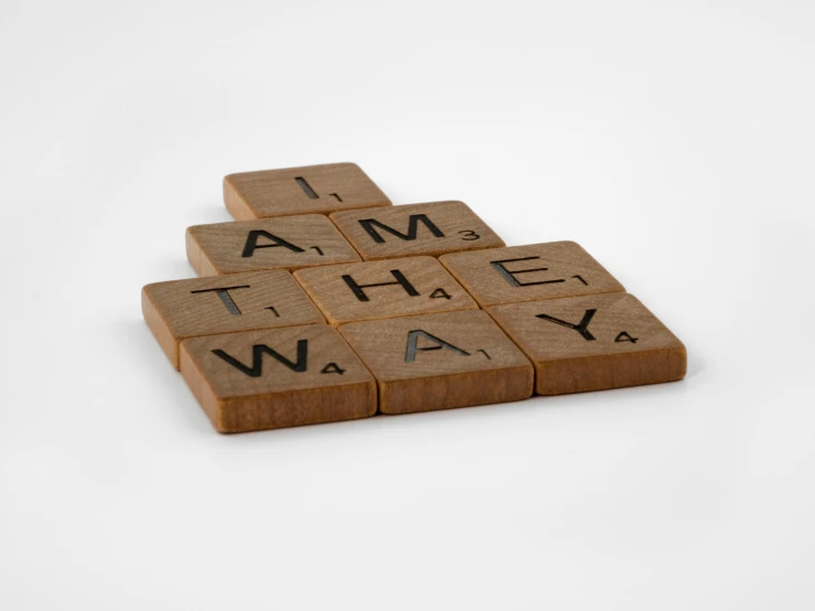 scrabbles spelling i am the way on a white background, temporary art, brown, product photograph, engraved, close up front view