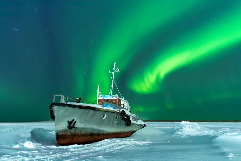 a boat that is sitting in the snow, pexels contest winner, green lightning, aurora aksnes, navy, national geographic quality