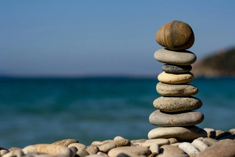 a stack of rocks sitting on top of a beach, a marble sculpture, acupuncture treatment, seaview, circular towers, beaches