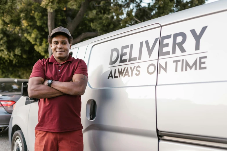 a man standing in front of a delivery van, 9 9 designs, dark-skinned, portrait image, in australia