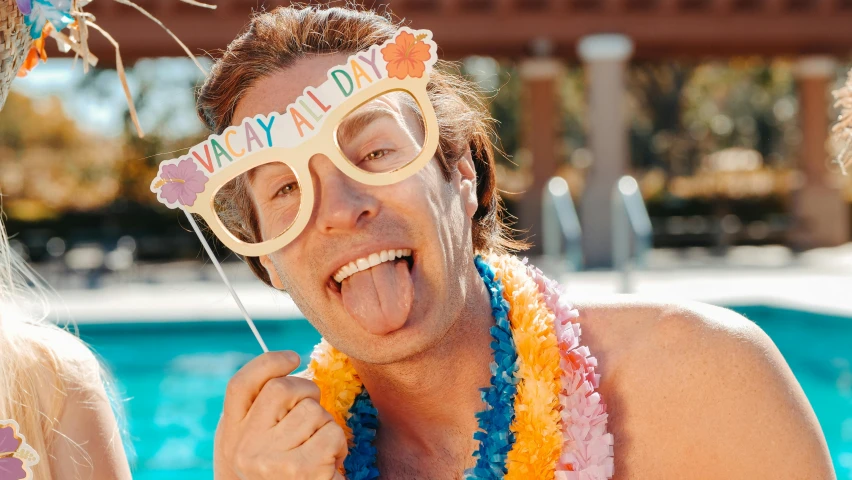 a man sticking his tongue out in front of a pool, tachisme, fancy dress, beach party, gofl course and swimming, good day